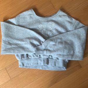 This is a Garage cropped gray sweater. With a white flower stitch design.
